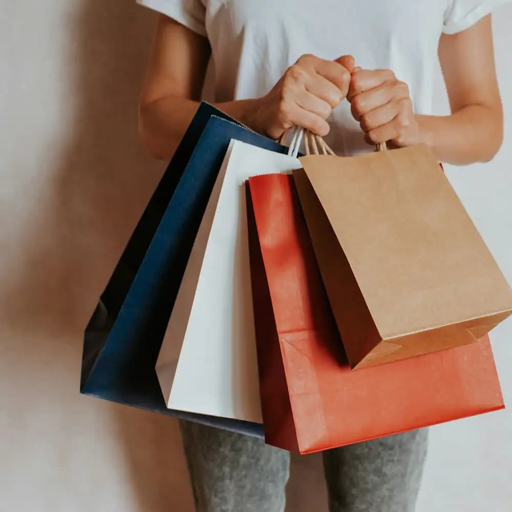 Mãos segurando sacolas de compras